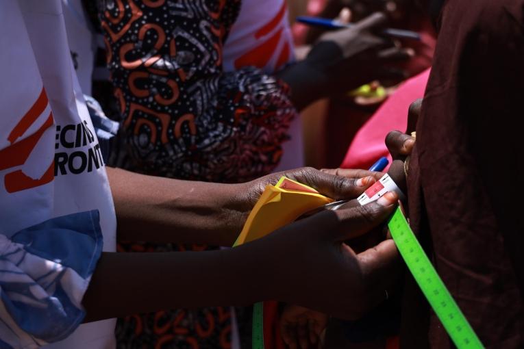 Un membre du personnel MSF mesure le périmètre brachial (MUAC) d'un enfant dans le camp de Gubio. Maiduguri, État de Borno, Nigeria, septembre 2024.