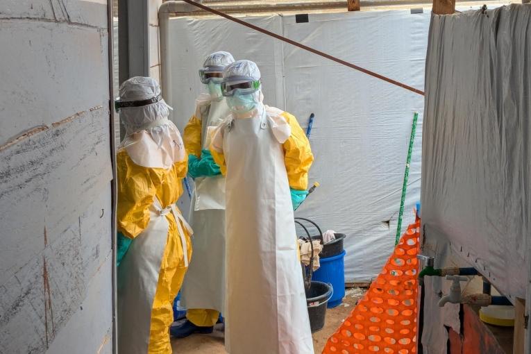 Des membres des équipes MSF et du ministère de la santé dans la zone rouge du centre de traitement d’Ebola de Kitatumba où ils vont décontaminer une chambre après le décès d’un patient souffrant d’Ebola. 