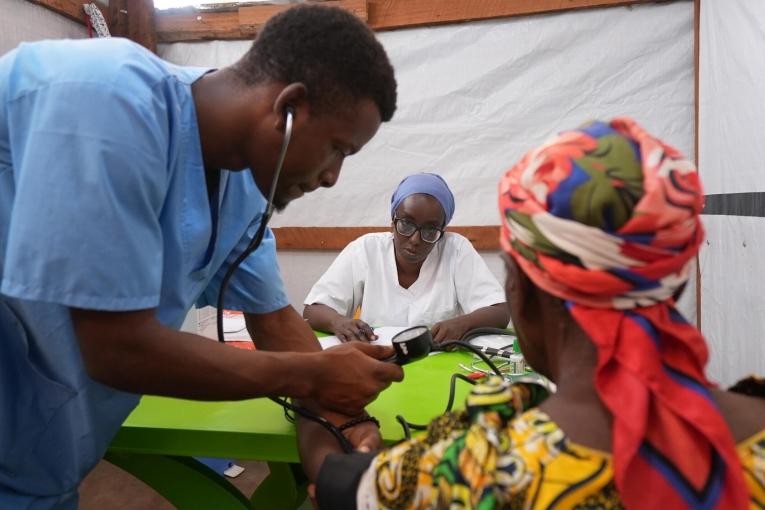 Au centre de santé de MSF, dans le camp de réfugiés de Busuma, des équipes médicales examinent un jeune patient accompagné de sa mère dans la salle de consultation.