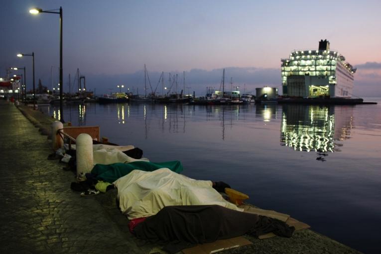 A l'aube des réfugiés dorment à même le sol dans le port de Kos.