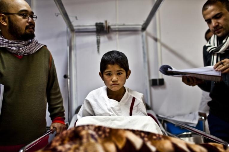 Enfant assis sur son lit à l'hôpital de Kunduz dans le nord de l'Afghanistan