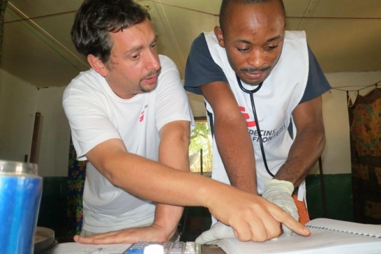 Docteur Thomas Mollet  chef de mission au Katanga analyse les registres d'admissons avec un collégue infirmier.