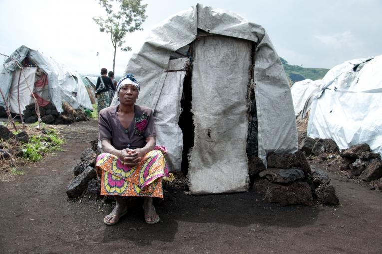 Comme Victorine cette femme déplacée se tient devant son abri dans le camp de Bulengo