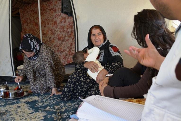 Invités dans la tente Shihab et Aala reçoivent du thé en présence de trois générations d'une même famille. Ils discutent de l'importance de l'alimentation et de l'exercice avec Fatima une réfugiée syrienne de 60 ans.