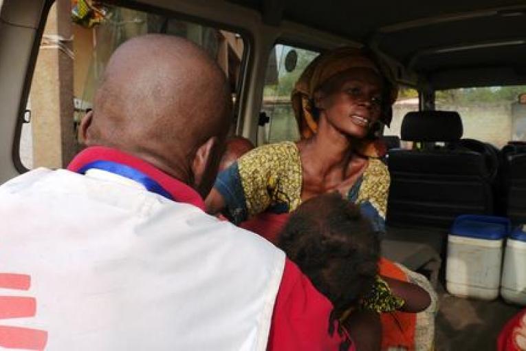 Stanislas Tatale agent de santé de MSF dans l'enclave de l'église de Carnot prépare le transfert vers l'hôpital d'une fillette malade.