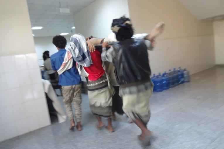 Un blessé est transporté en civière au service chirurgical d'urgence de MSF à Aden Yémen. Avril 2015.