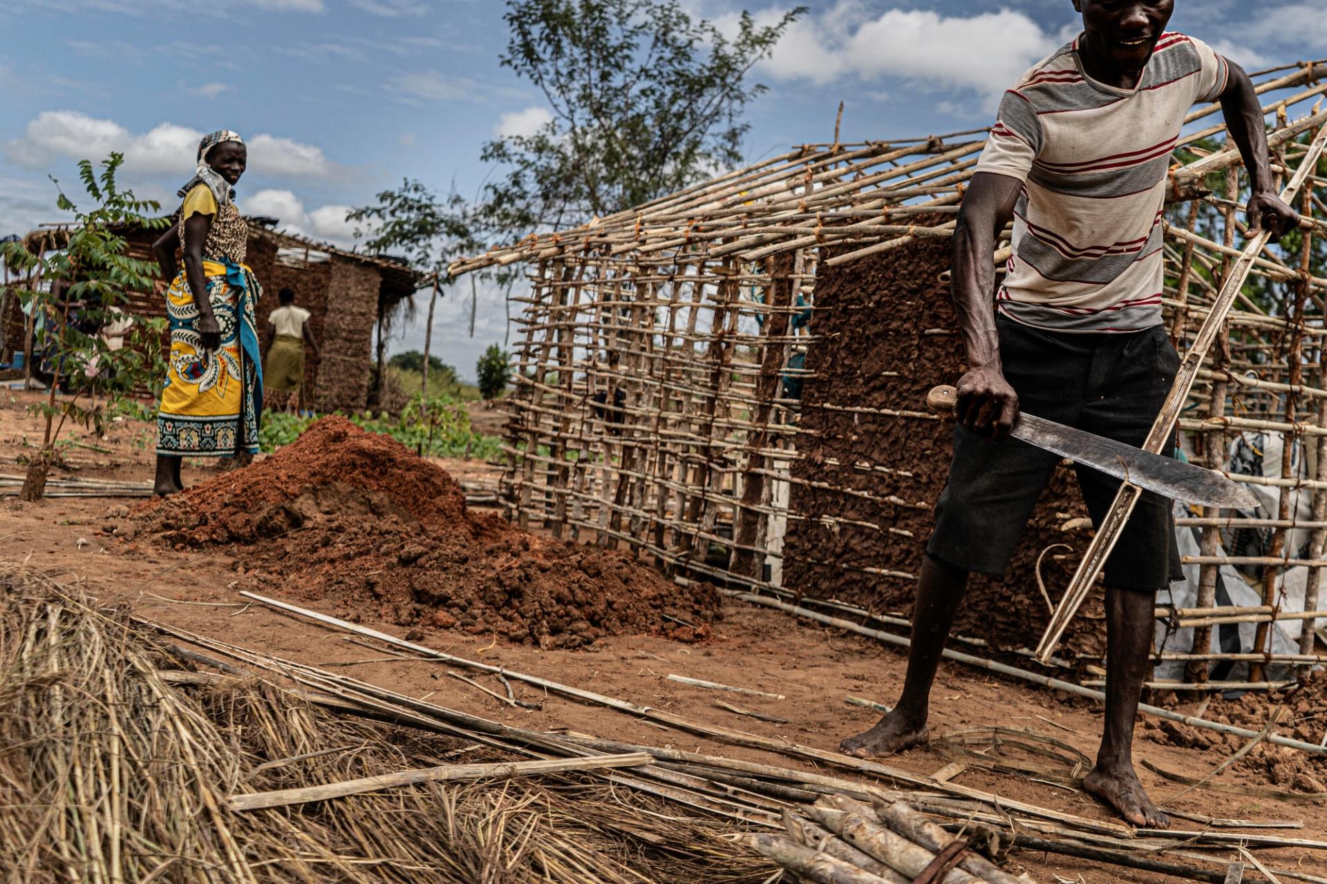 Un homme et une femme construisent une hutte dans le camp pour personnes déplacées de Mapupulu. Ils ont fui les violences dans la province de Cabo Delgado. 