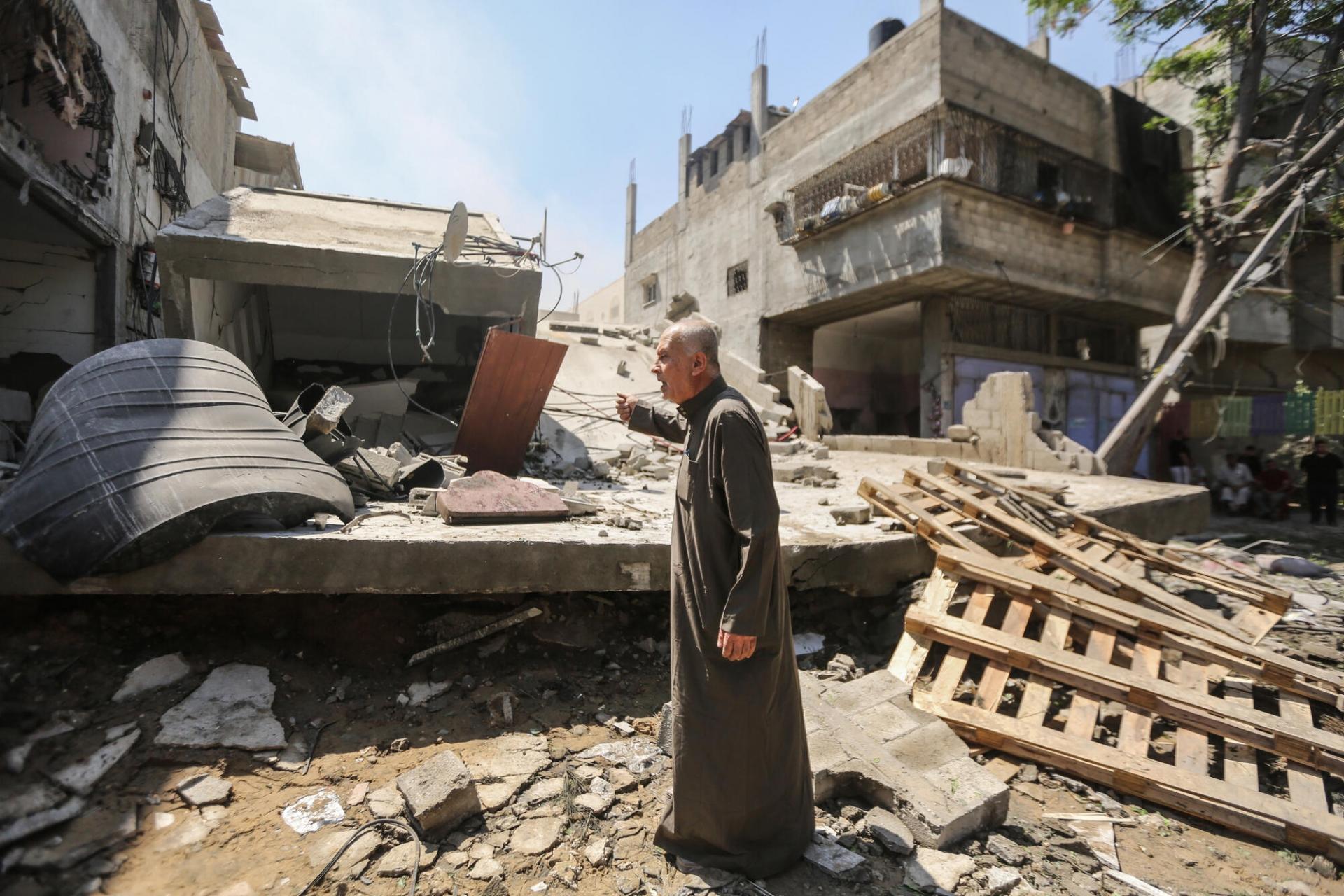 (gauche) À Gaza, une jeune femme marche dans les décombres d’un immeuble partiellement détruit par un bombardement aérien. (droite) Un homme âgé se tient debout au milieu des ruines de son quartier à Gaza. Onze jours de frappes israéliennes massives, de nuit comme de jour, ont causé des dégâts immenses dans l’enclave au mois de mai. 