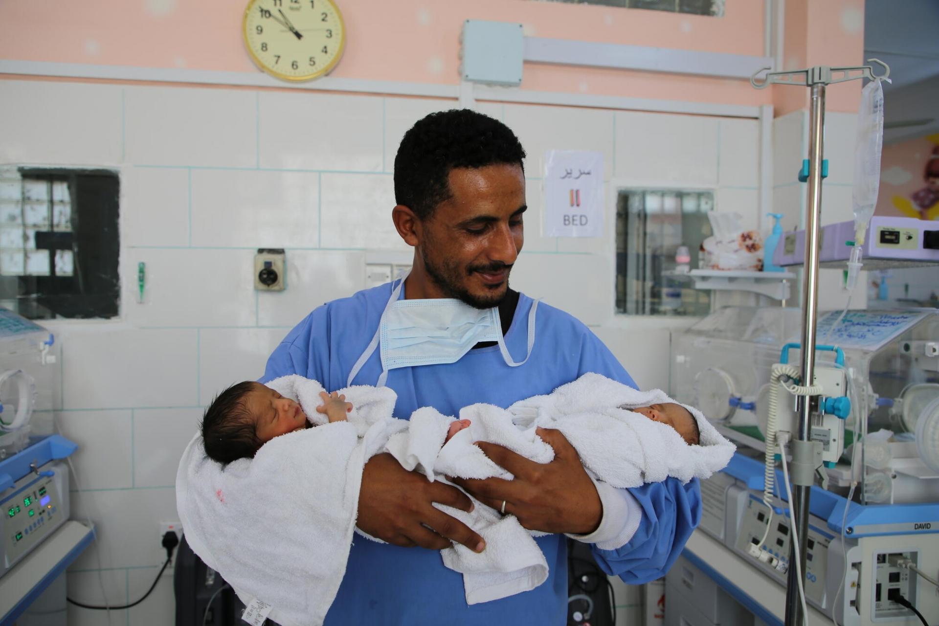 Wael Abdul Jabbar Mahyub tient dans ses bras ses jumelles Heba et Malath, prises en charge au sein de l’unité spéciale pour les nourrissons de l’hôpital Al Jamhouri à Taiz, au Yémen.