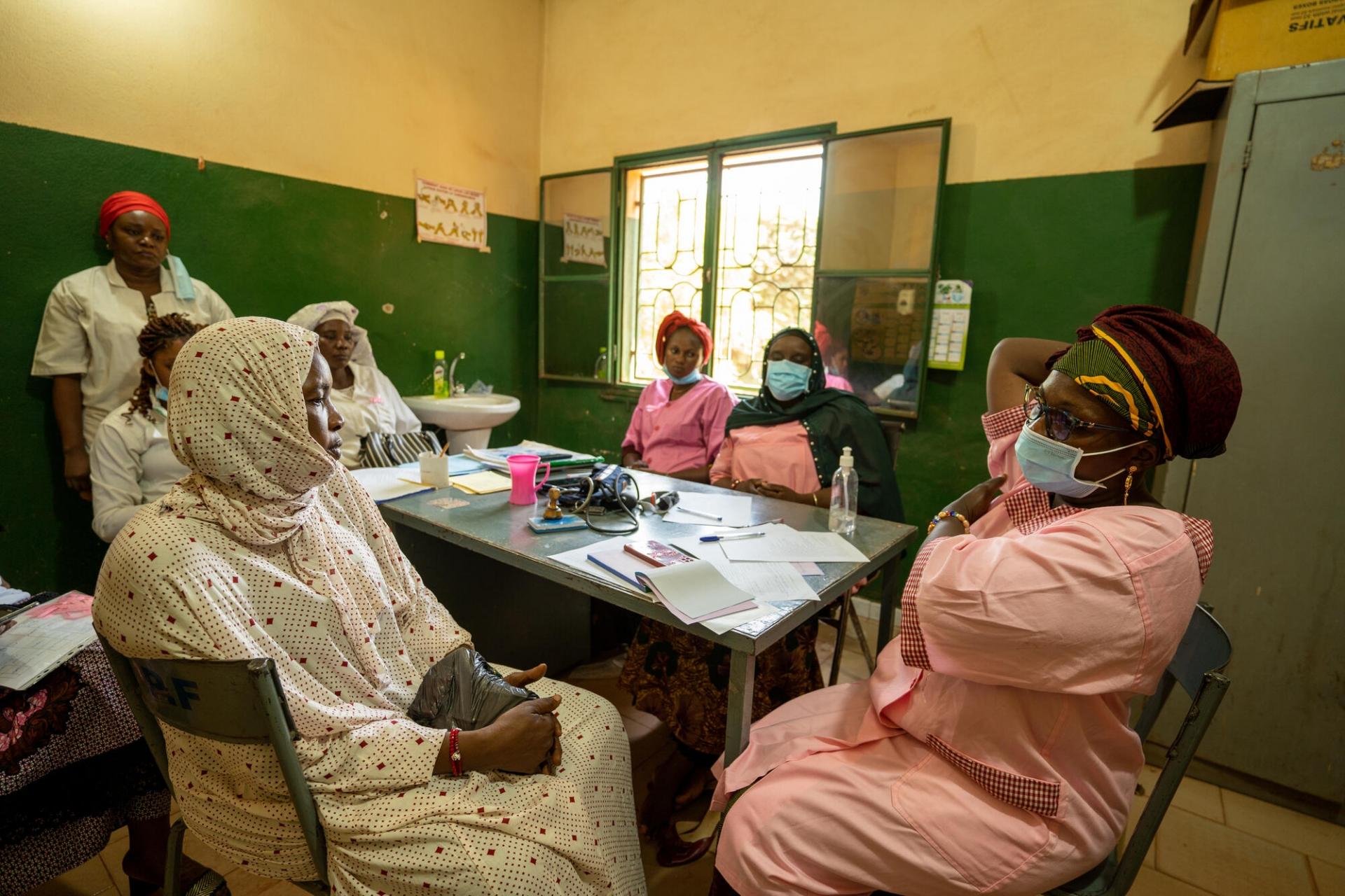 Diawara Fatouma Dicko (droite) travaille au centre de santé de Yirimadio à Bamako. Elle explique à une patiente les mouvements pour réaliser une autopalpation des seins afin de s'assurer de l'absence d'anomalies.