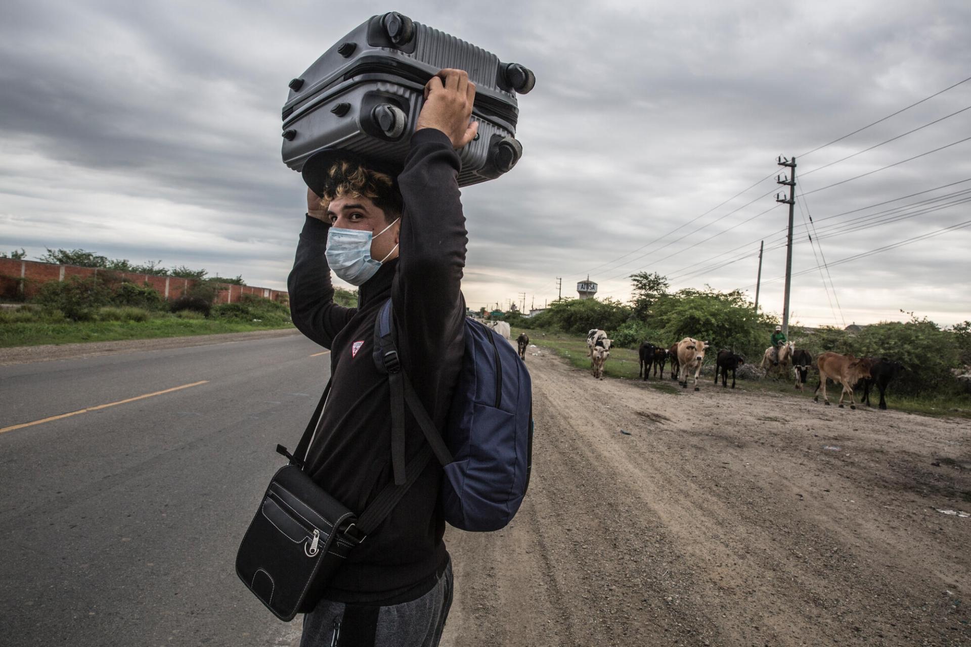 Un jeune migrant vénézuélien marche le long de la route panaméricaine pour rejoindre Tumbes au Pérou, à la frontière avec l’Équateur. Pérou, mars 2022