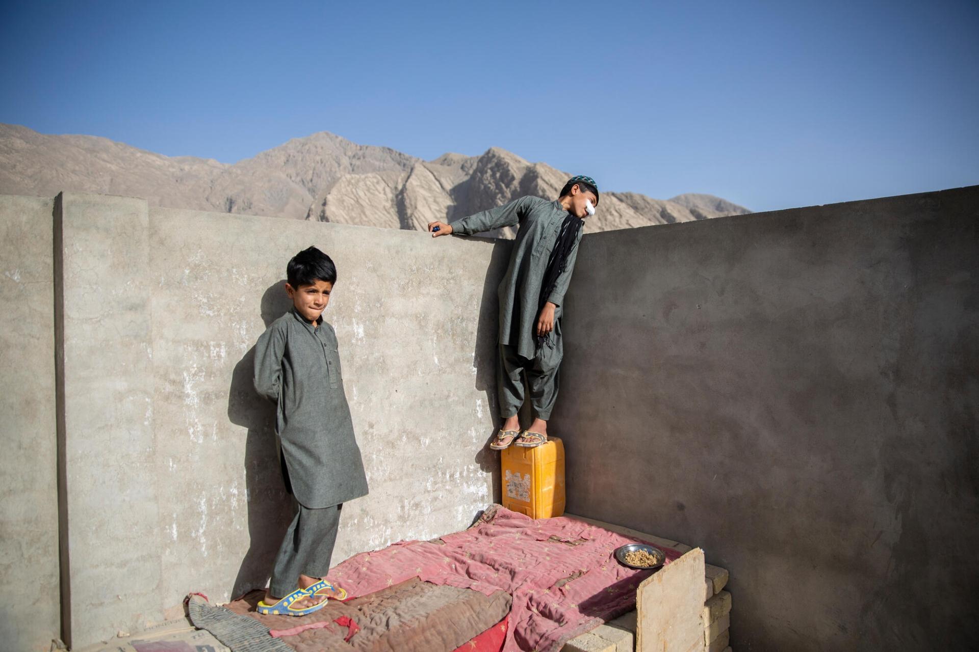 Idris (droite) joue avec son petit frère Mohammad (gauche) sur le toit de leur maison de Quetta. Le garçon de dix ans souffre de leishmaniose cutanée, pour laquelle il est soigné à la clinique MSF de l’hôpital Benazir Bhutto. Pakistan, mai 2022