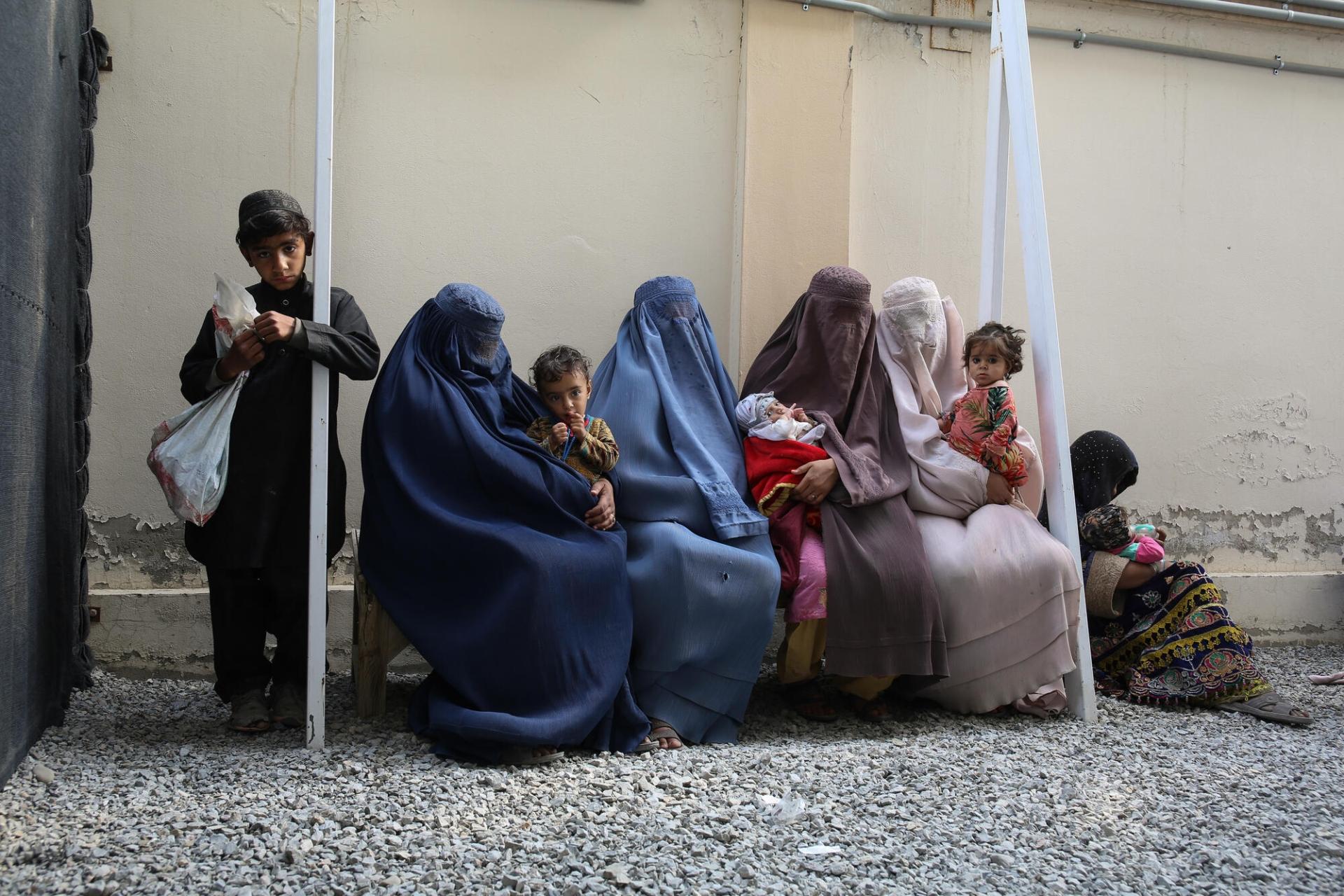 Un groupe de femmes et d’enfants attendent sur un banc dans le centre nutritionnel thérapeutique de MSF situé dans la ville de Kandahar, en Afghanistan. Afghanistan, mars 2022