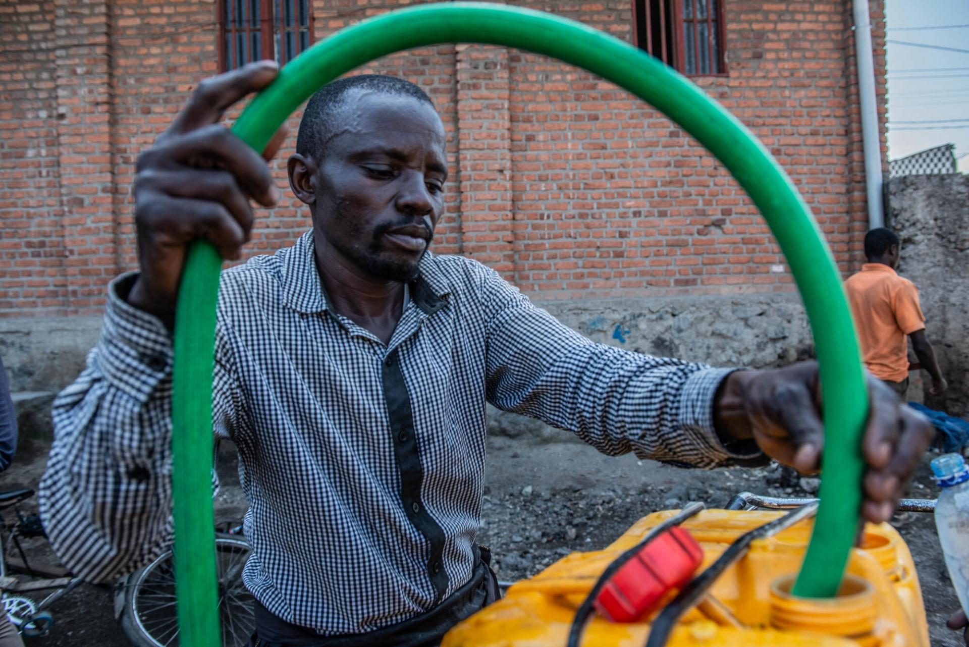 Jean-Claude Bazibuhe remplit des jerricans d'eau potable dans la villle de Goma.