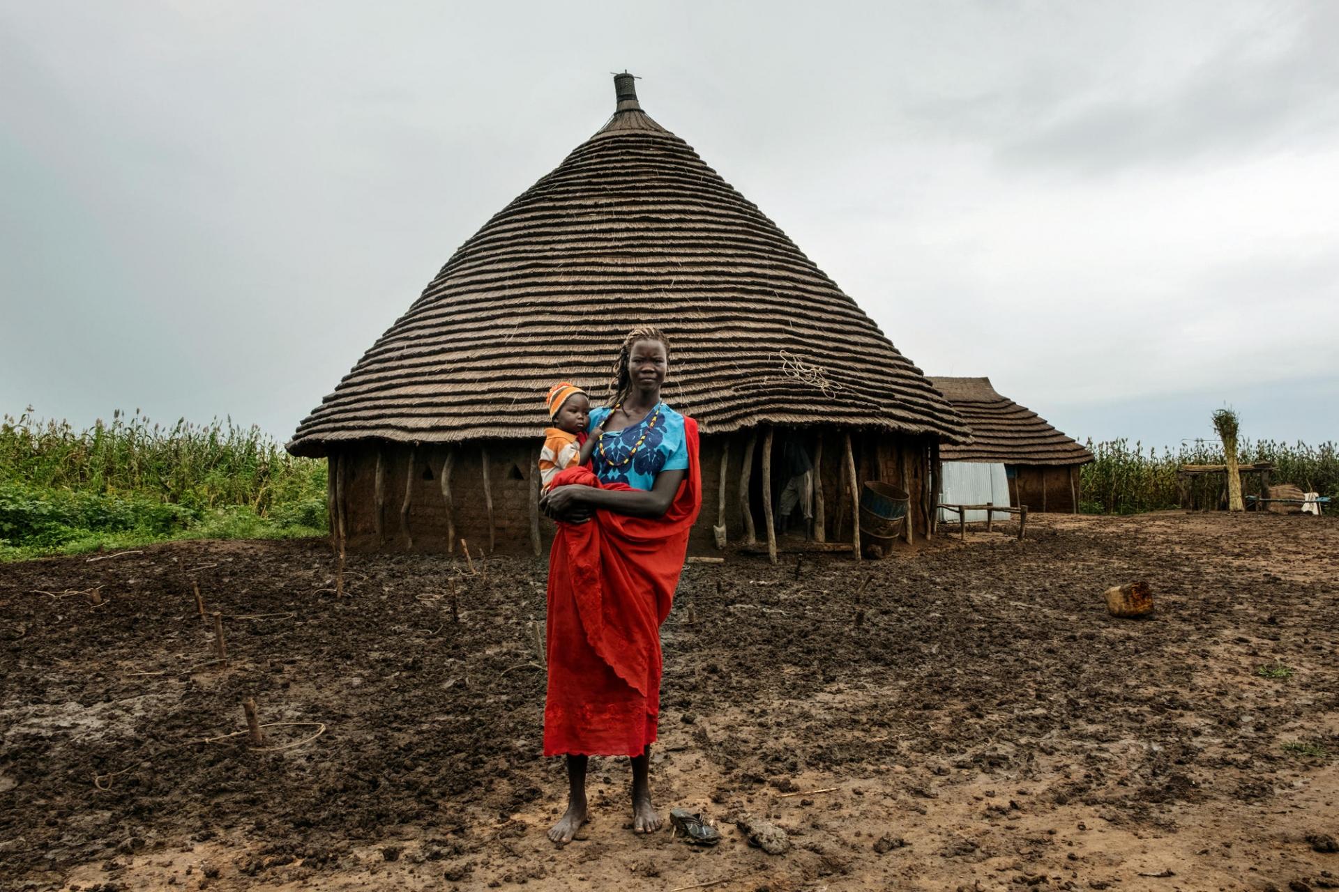 Anger et son fils devant un tukul, une habitation traditionnelle de cette région du Soudan du Sud.