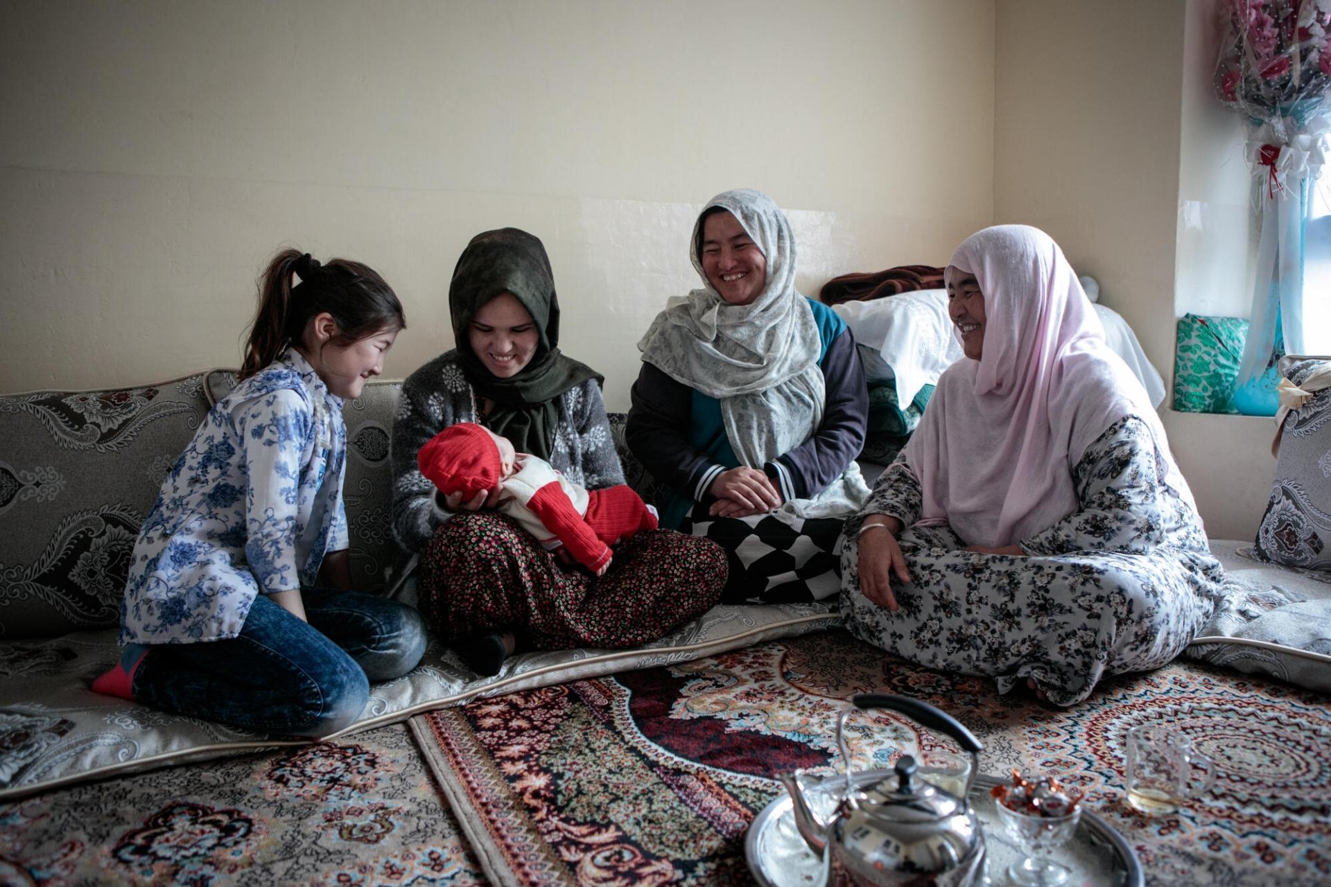 Hosnia s’est mariée l’année dernière. Elle vit depuis avec son mari chez sa belle-famille, comme la tradition afghane le veut. 10 personnes habitent dans la maison : la jeune femme, son mari et leur fille, ainsi que les beaux-parents, le frère et les quatre sœurs de l’époux. Dans leur chambre, Hosnia partage un thé avec sa belle-mère et sa jeune nièce.