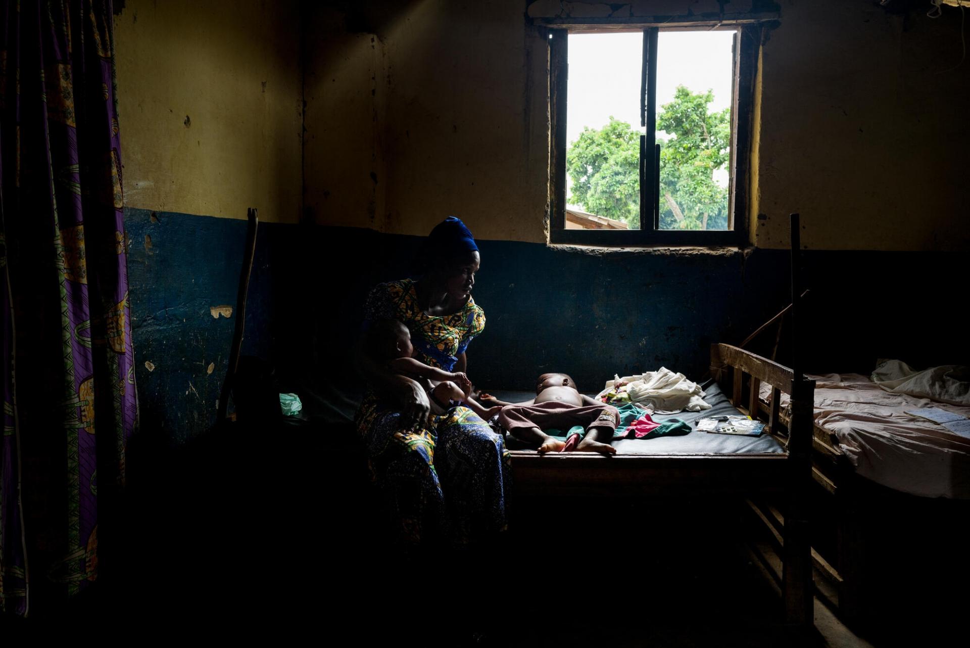 Une jeune femme et ses enfants hospitalisée dans le centre de santé de Nzacko. Son fils de deux ans est atteint par le paludisme et une maladie de peau. Juillet 2021.
