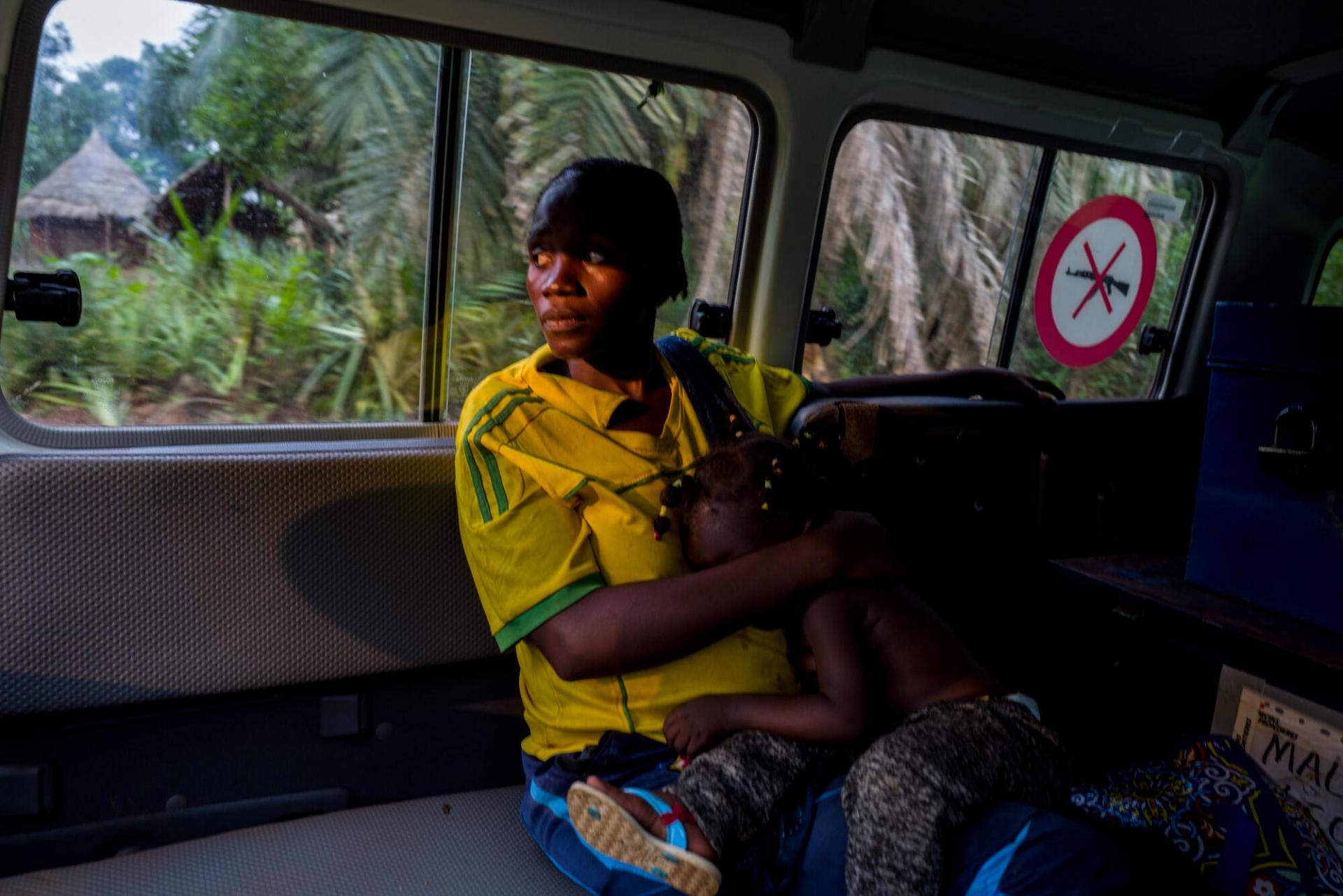 Véronique est transférée de Nzacko à Bangassou dans une voiture MSF. Elle est au septième mois de sa grossesse. Elle est accompagnée de sa plus jeune fille. Juillet 2021.