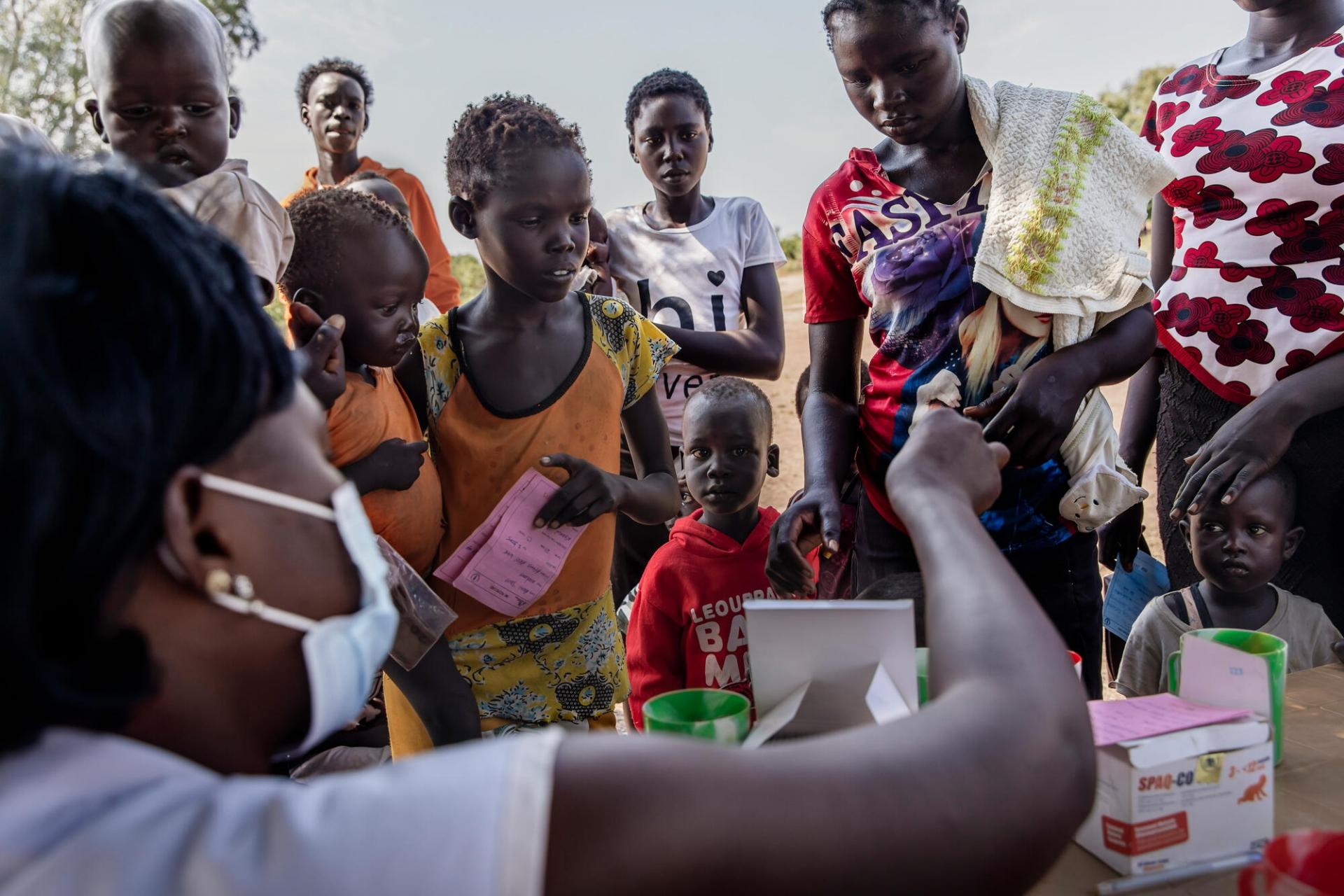 Des enfants reçoivent des médicaments de chimioprévention du paludisme saisonnier sur un site de distribution dans un village proche d'Aweil. Octobre 2021.