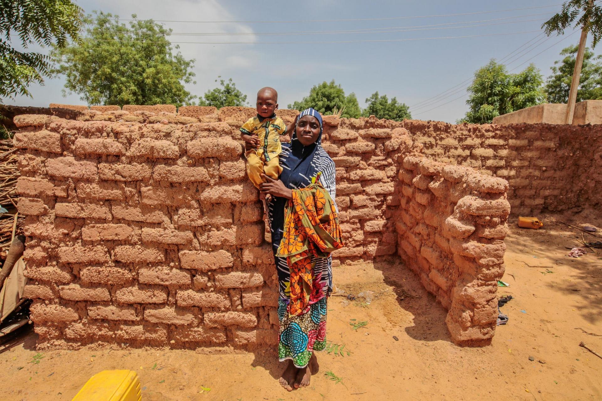 Portraits de Shafaatu Hashimu (gauche) et Sherusi Aminu (droite), accompagnées de leurs filles respectives. Souffrant de malnutrition, les deux enfants ont été prises en charge dans le centre nutritionnel thérapeutique ambulatoire MSF du village de Riko, à la frontière entre le Niger et le Nigeria. État de Katsina, Nigeria, juin 2022.