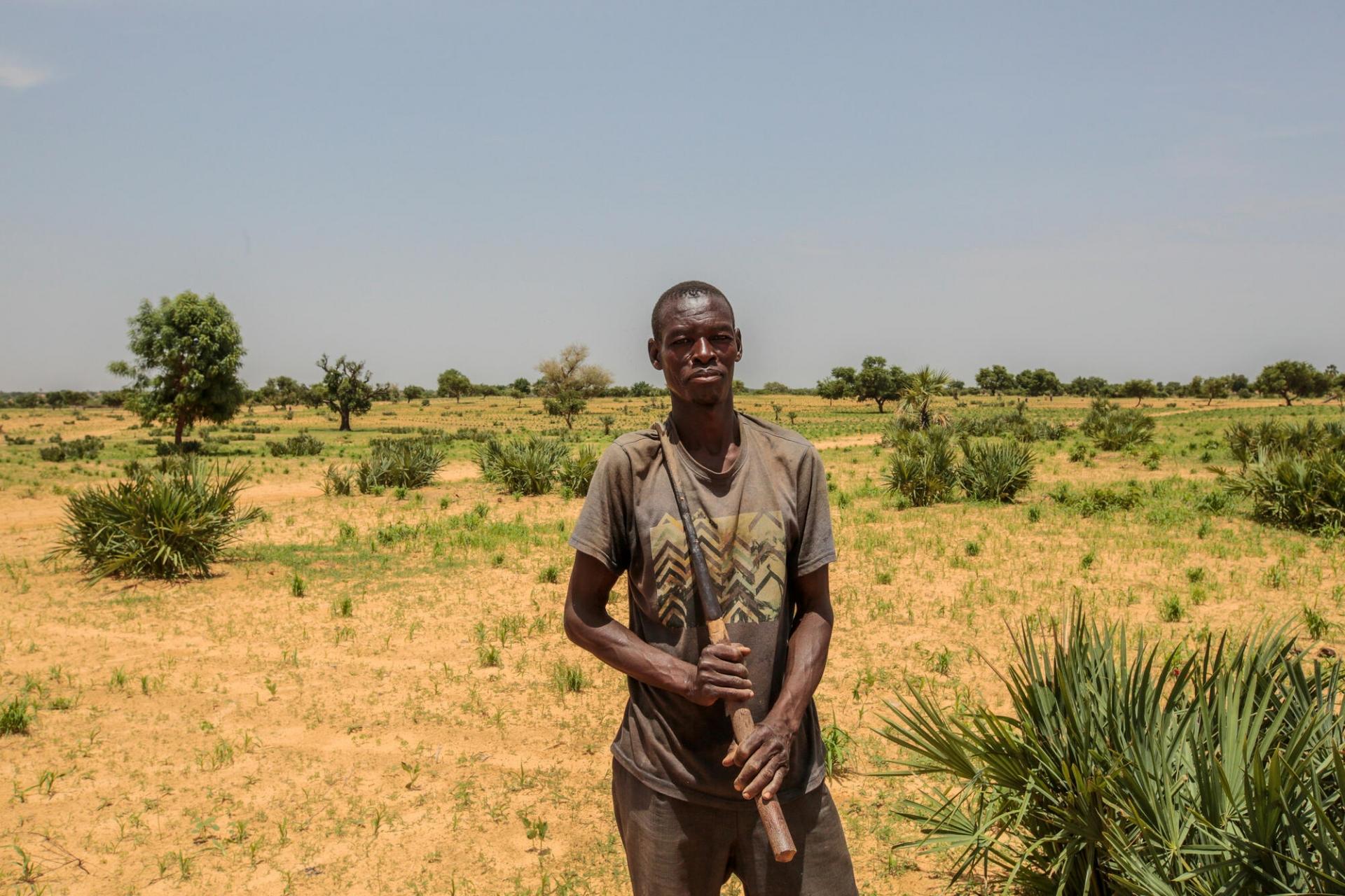 Portrait d’Umar Abdul, fermier et agriculteur, dans les champs près du village de Riko.  Les attaques répétées de groupes armés, appelés « bandits », empêchent les habitants comme Umar d’accéder à leurs champs et de cultiver leurs terres, ce qui contribue à aggraver la crise nutritionnelle en cours. État de Katsina, Nigeria, juin 2022. 