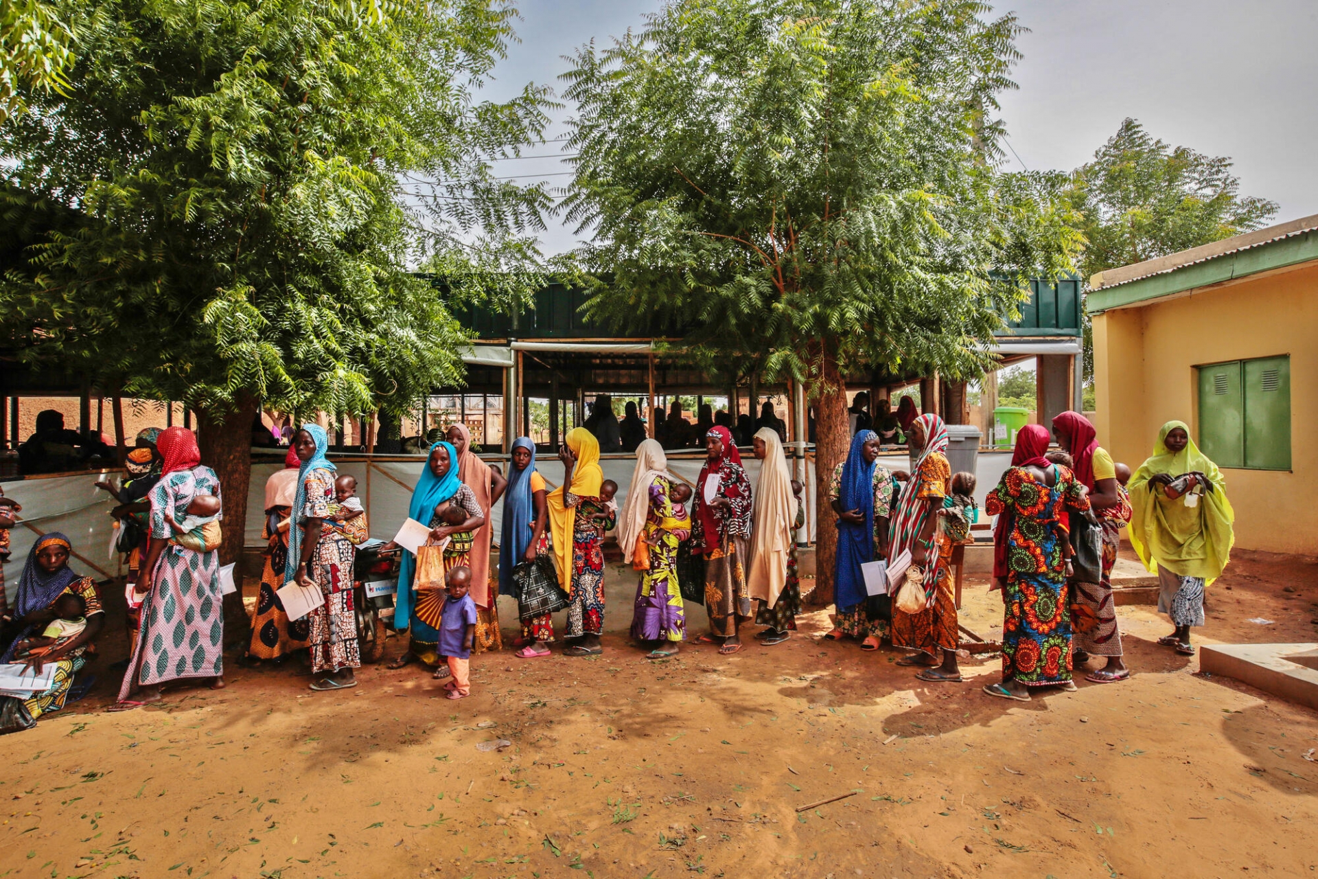 File d’attente au centre nutritionnel thérapeutique ambulatoire de MSF à Riko.  Nombreuses sont les mères nigérianes de la région à se rendre au Niger voisin, situé à quelques kilomètres de là, pour faire soigner leurs enfants. Côté Niger, MSF est présente dans la région frontalière de Maradi : en 2021, 70% des enfants souffrant de malnutrition admis dans ce programme venaient du Nigeria. État de Katsina, Nigeria, juin 2022. 