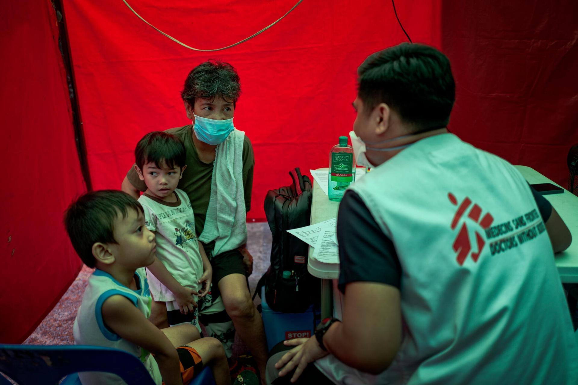 Une grand-mère avec ses petits-enfants, en consultation avec Trisha Thadhani, médecin MSF. Manille. Philippines. 13 mars 2023.