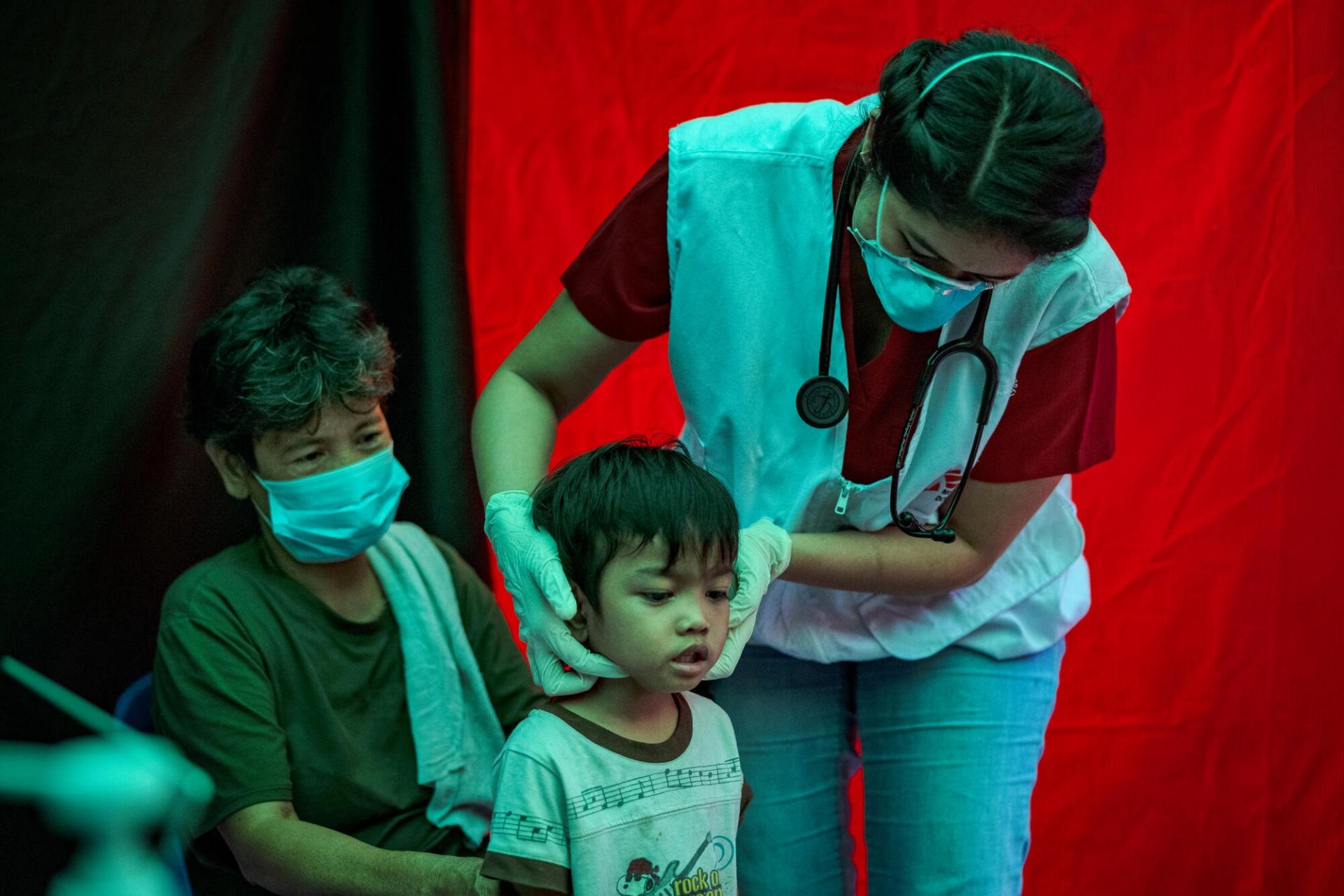 Une grand-mère avec ses petits-enfants, en consultation avec Trisha Thadhani, médecin MSF. Manille. Philippines. 13 mars 2023.