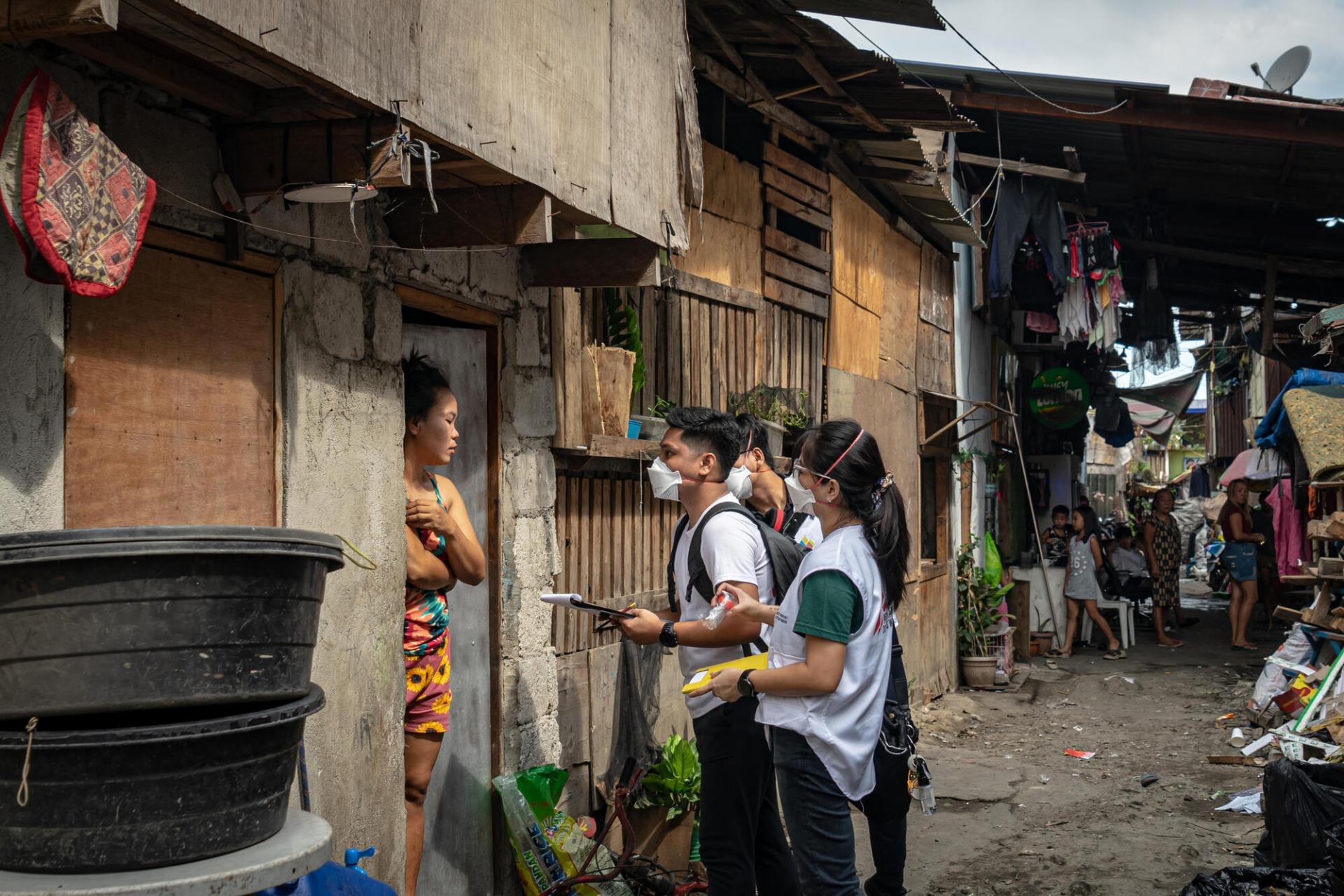 Des membres de l'équipe MSF de soutien aux patients en discussion avec une habitante de Tondo, Manille. Philippines. 2 mars 2023.
