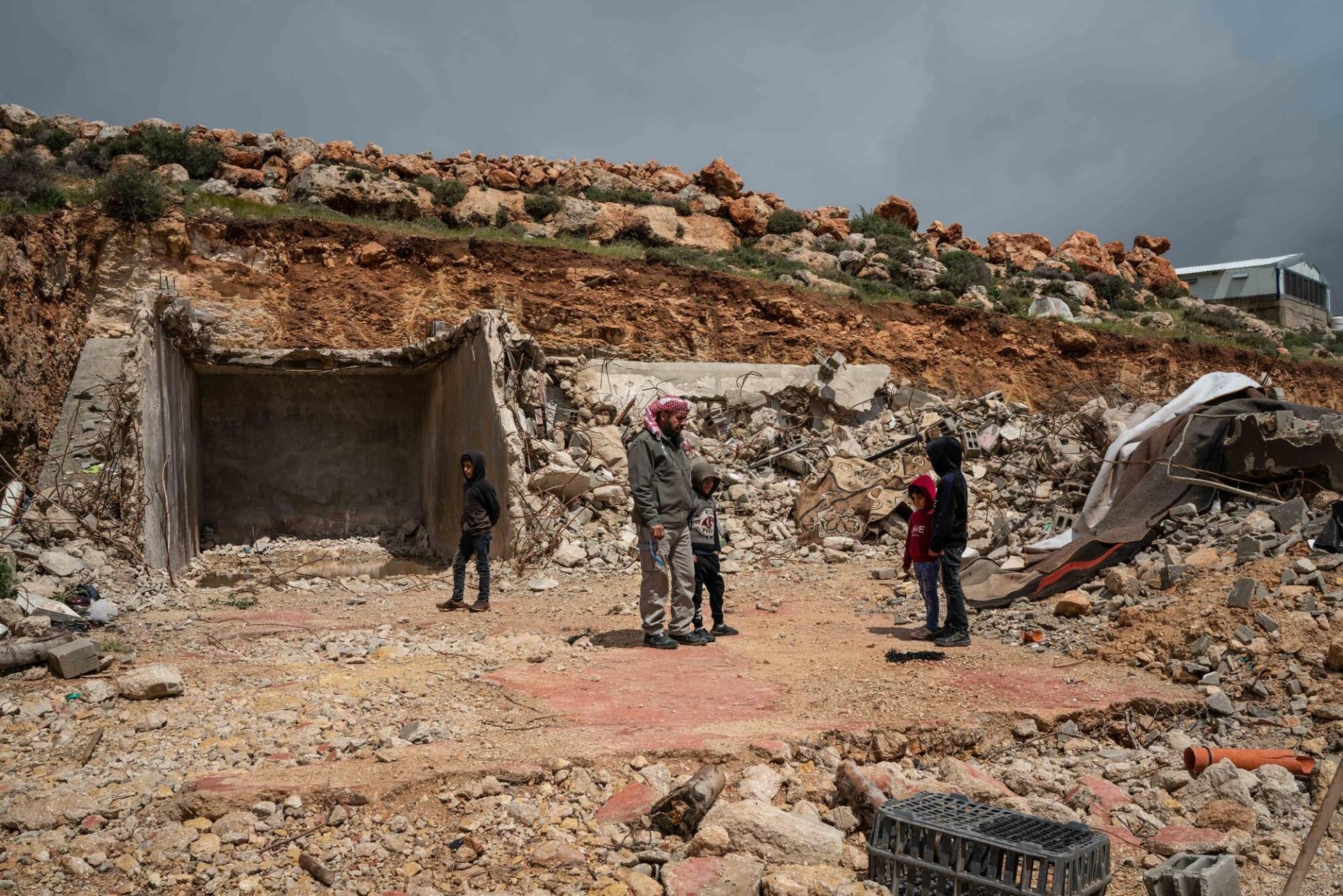 Mustafa et ses enfants au milieu des décombres de leur maison démolie par les forces israéliennes. Avril 2023. Cisjordanie.