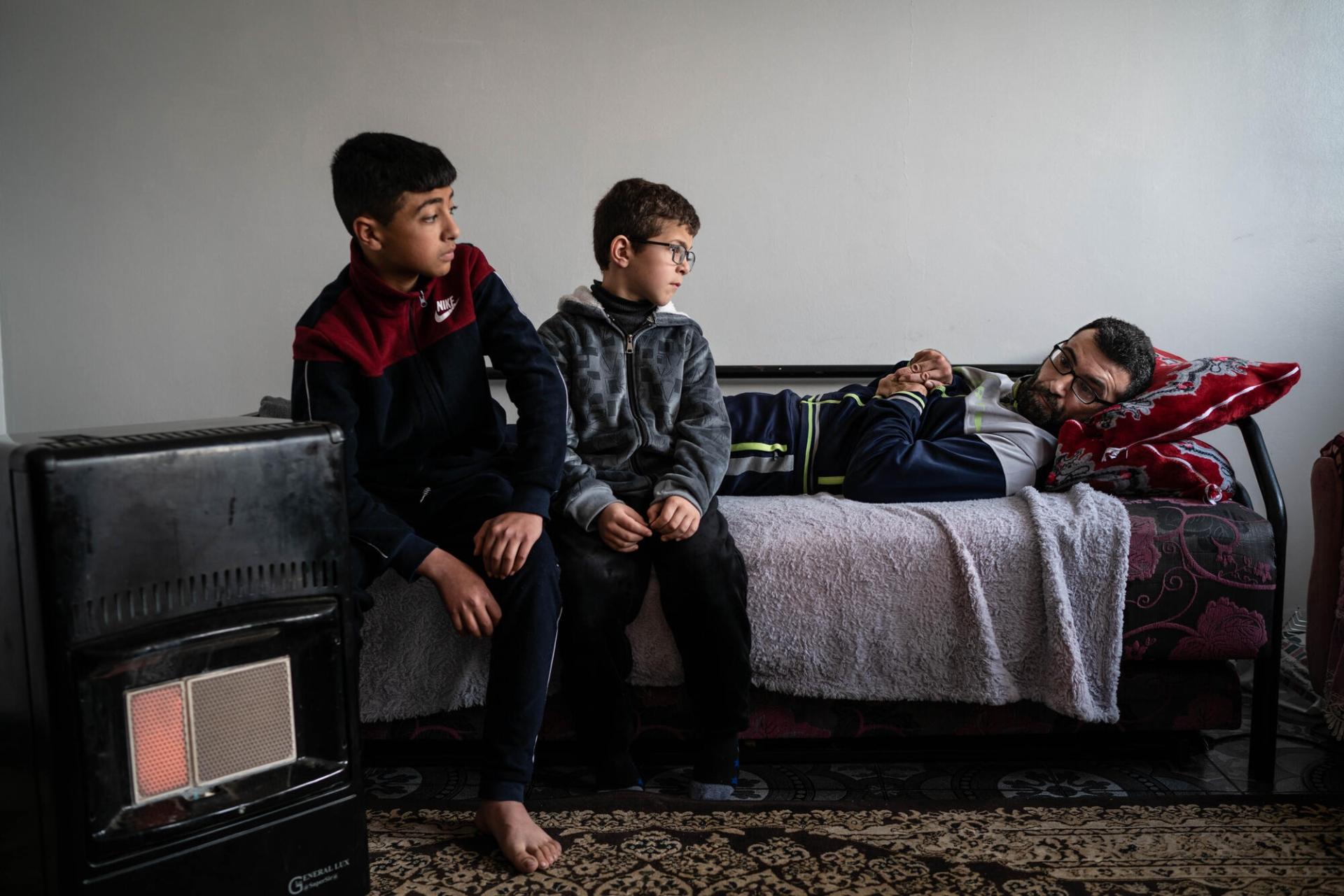 Hussam, son cousin et son oncle, paraplégique, dans leur maison de Huwara. Avril 2023. Cisjordanie.