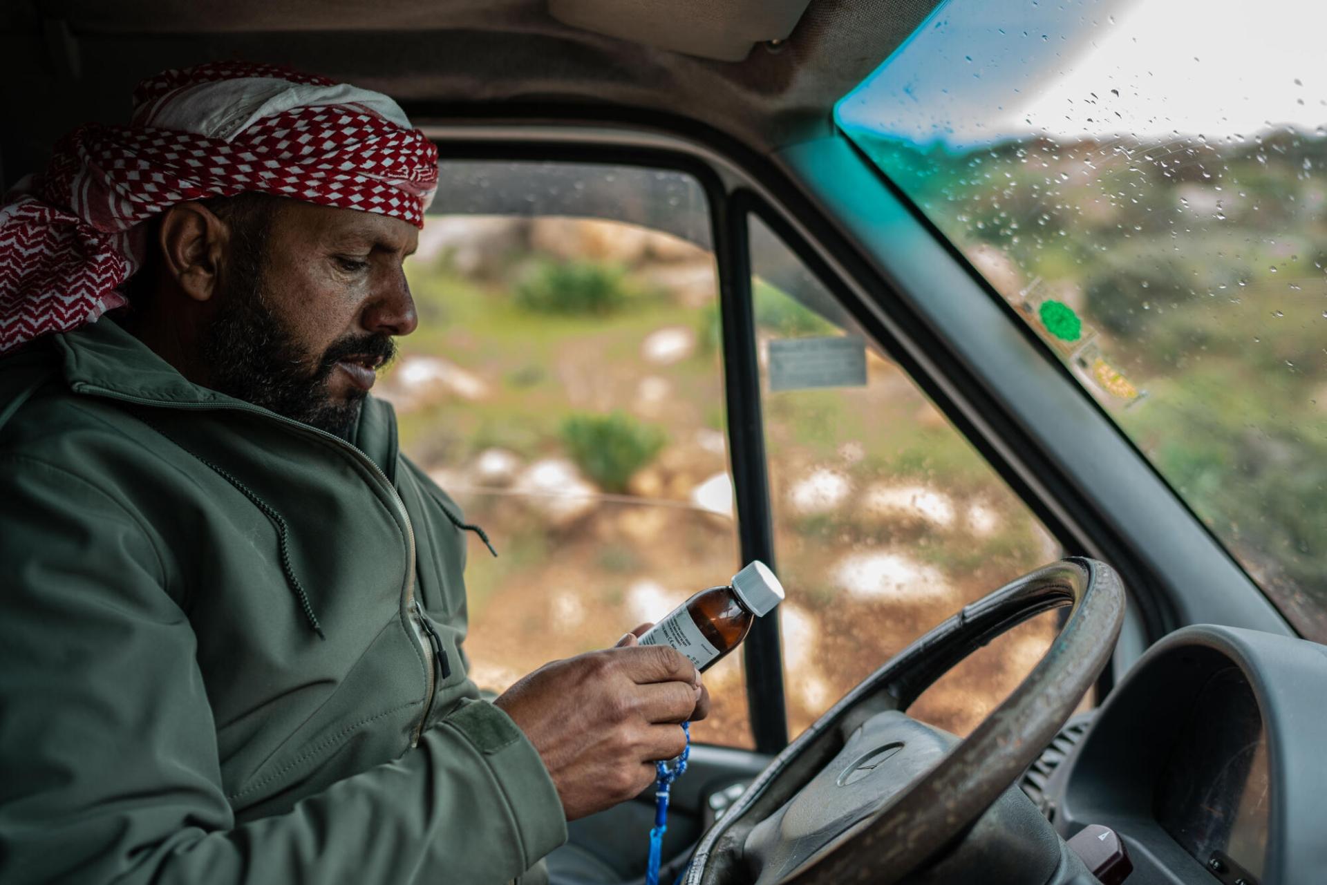 Mustafa dans sa voiture, inspecte un médicament qu'il doit racheter pour son fils. Avril 2023.