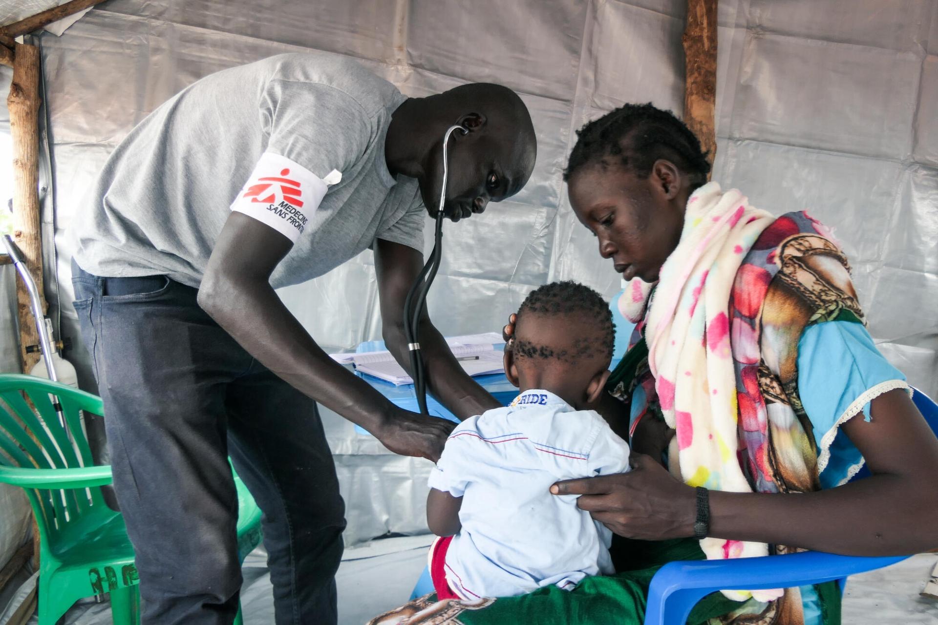 MSF Clinical Officer Chuol Hoth examines a child