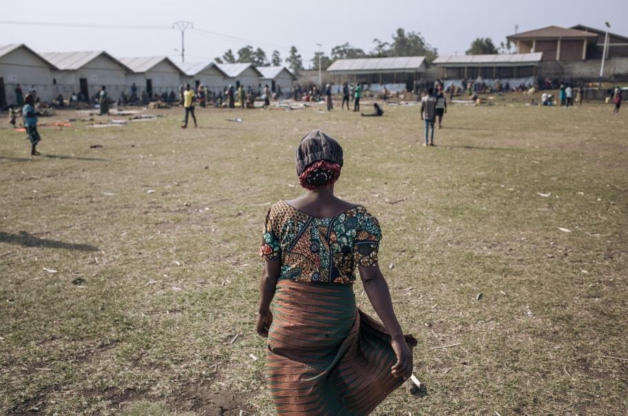 Agrippine, veuve déplacée de 53 ans, marche au sein du site informel de déplacés du stade de Rugabo, dans le centre de Rutshuru.