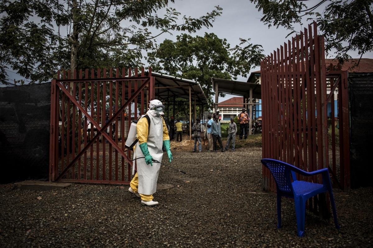 Un travailleur de santé MSF désinfecte l'entrée du centre d'isolement de Bunia après l'admission d'un patient affecté par Ebola. 2018. République démocratique du Congo.&nbsp;
 © John Wessels