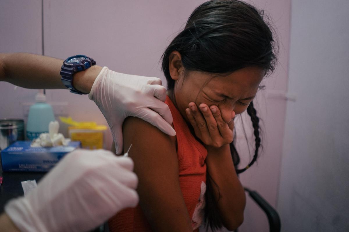 Une jeune fille du quartier de Tondo, à Manille, est vaccinée contre le HPV dans un dispensaire de l'ONG Likhaan, partenaire de MSF. Likhaan fournit des services de soins de santé en matière de reproduction aux familles à faible revenu aux Philippines, où il existe encore un écart dans la sensibilisation des femmes à leurs droits en matière de procréation.
© Hannah Reyes Morales