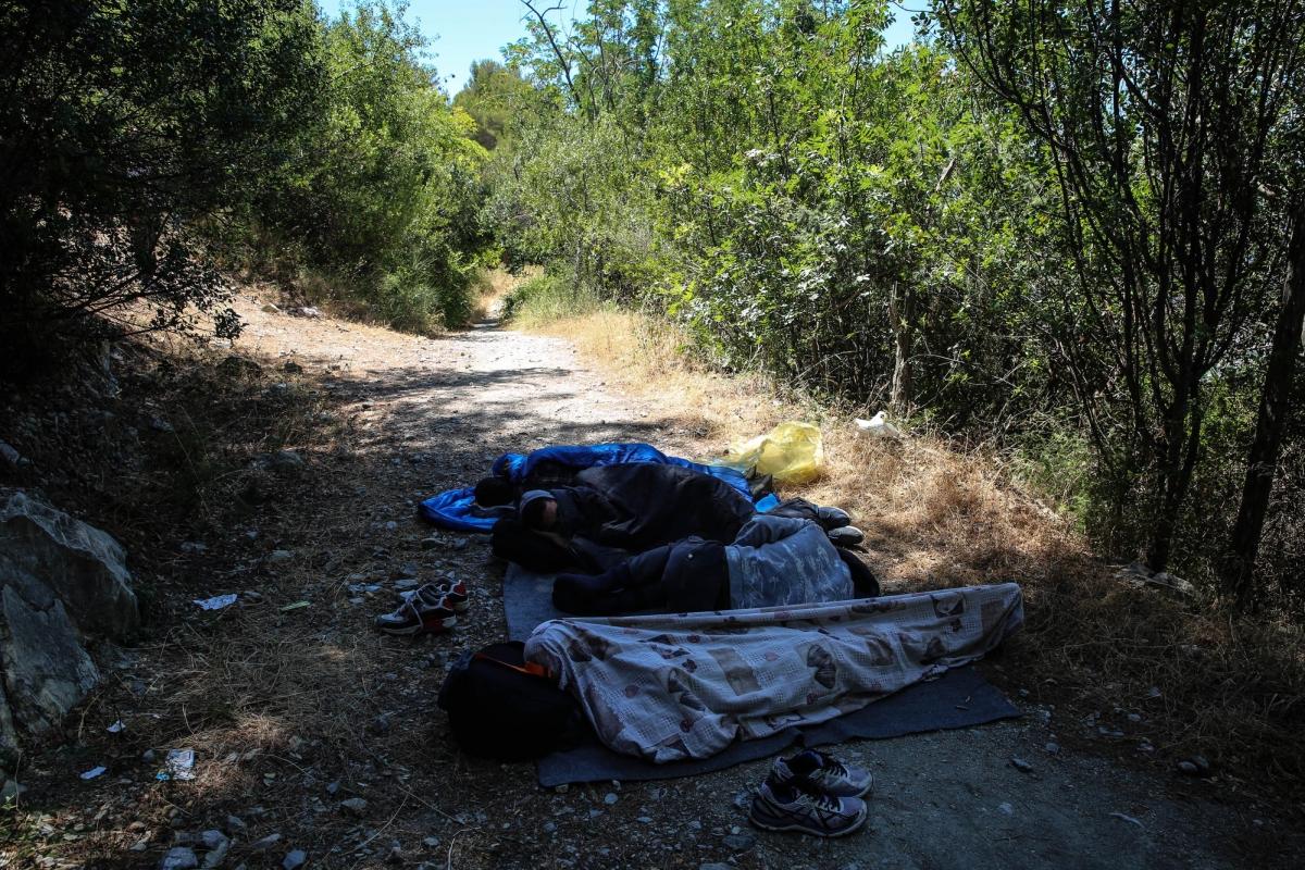 Des personnes dorment aux pieds des montagnes, côté italien, en attendant la tombée de la nuit avant de rejoindre la France. Juillet 2017.
 © Mohammad Ghannam/MSF