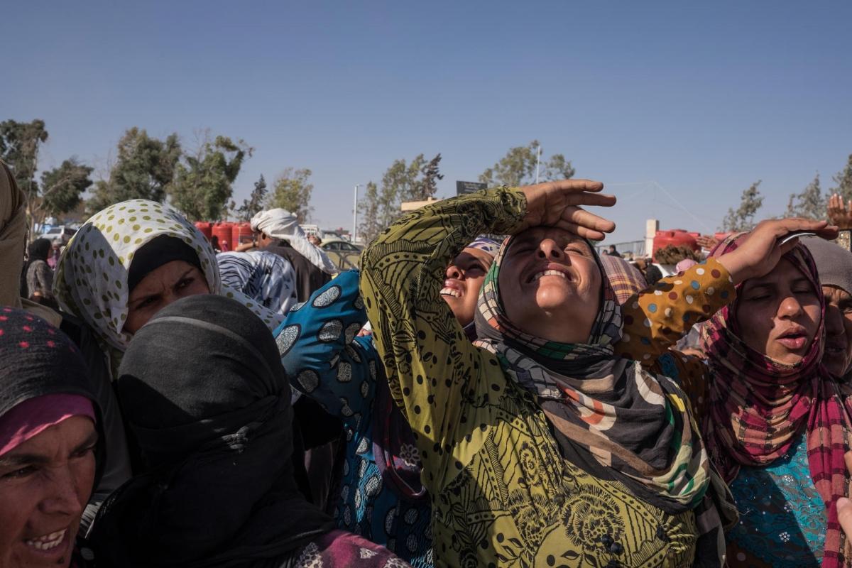 Des femmes du camp d'Aïn Issa regardent un avion militaire voler à basse altitude en direction de Rakka.
 © Agnes Varraine-Leca