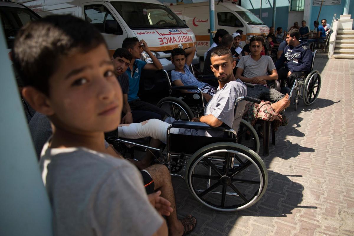 File d'attente dans la clinique de Beit Lahia. Des patients tentent de se mettre à l'ombre sur le parking de l'ambulance. Bande de Gaza. 2018.
 © Aurelie Baumel/MSF