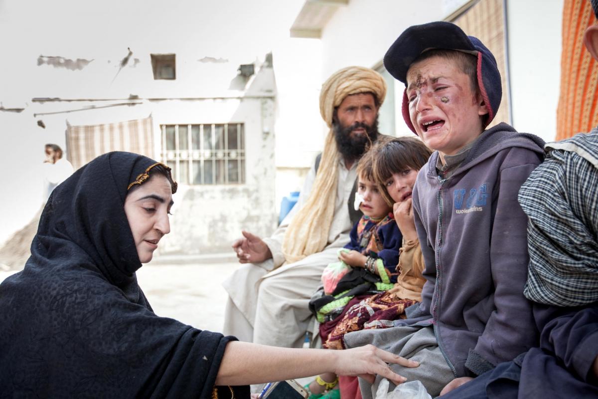 Une conseillère MSF rassure un jeune garçon avant qu'il reçoive son traitement contre la leishmaniose cutanée dans la clinique de Kuchlak. Pakistan. 2018.&nbsp;
 © Khaula Jamil