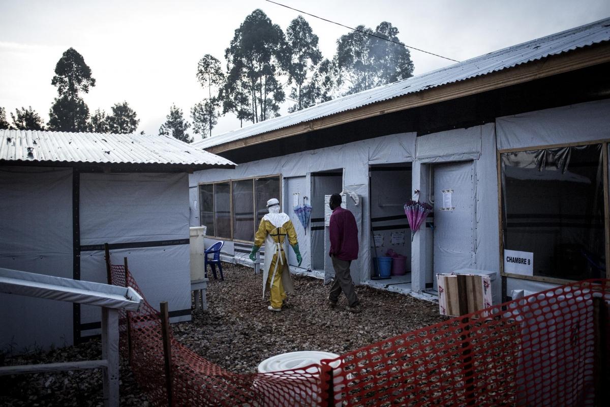 Un travailleur de santé MSF accompagne un homme susceptible d'être atteint par Ebola. Centre de traitement Ebola de Butembo. République démocratique du Congo. 2018.
 © John Wessels