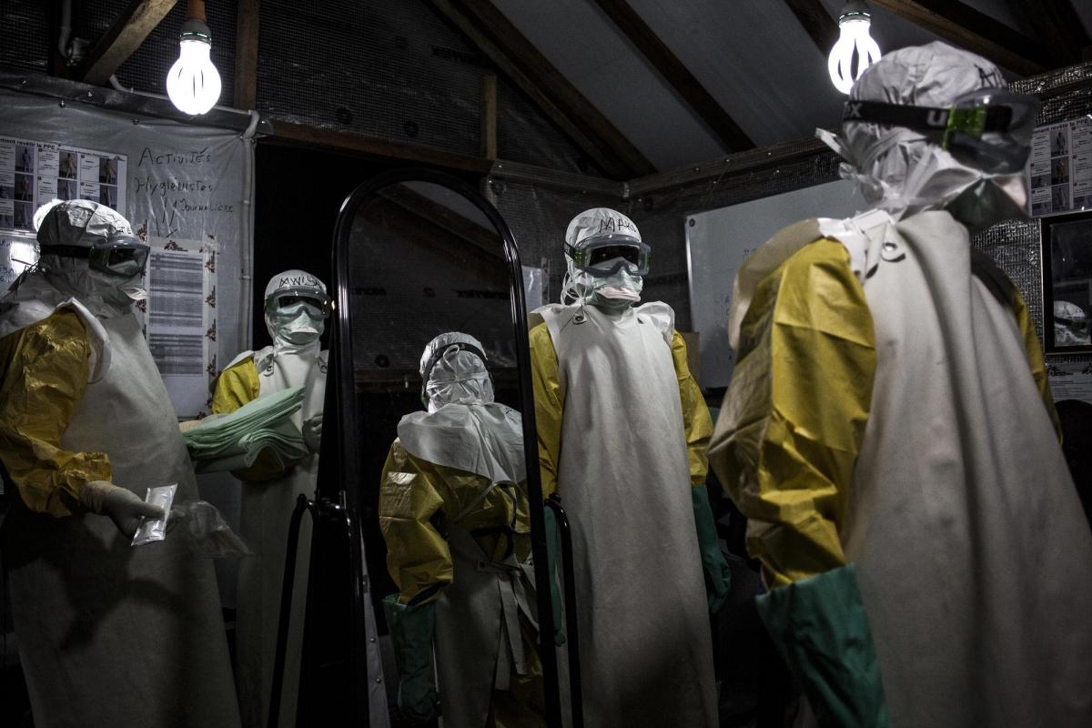 Des travailleurs de santé MSF revêtent leur équipement de protection personnel avant d'entrer dans la zone à risque du centre de traitement Ebola de Butembo. Il vont procéder à une évaluation de l'état des patients. Novembre 2018. République démocratique du Congo.
 © John Wessels