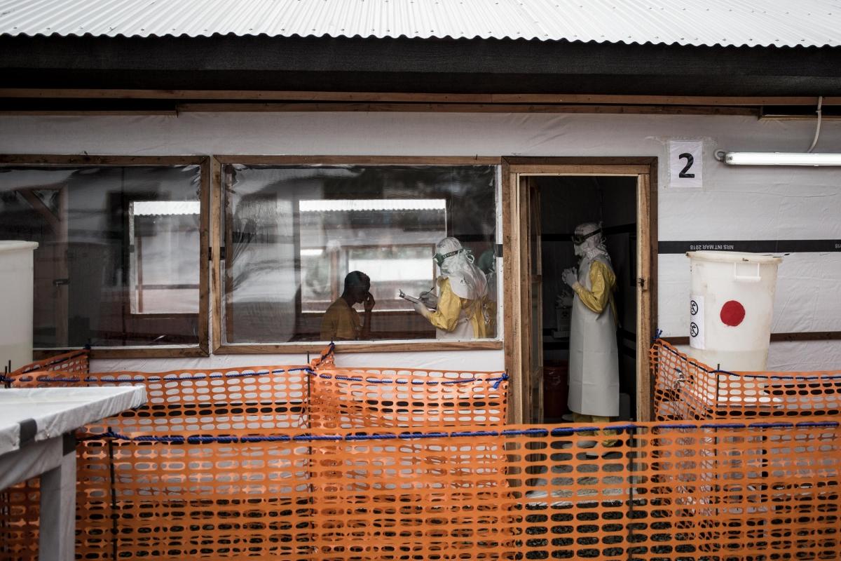 Des travailleurs de santé MSF réalisent l'évaluation médicale d'un patient possiblement affecté par Ebola. Ils sont à l'intérieur du centre d'isolement Ebola de Bunia. Novembre 2018. République démocratique du Congo.
 © John Wessels