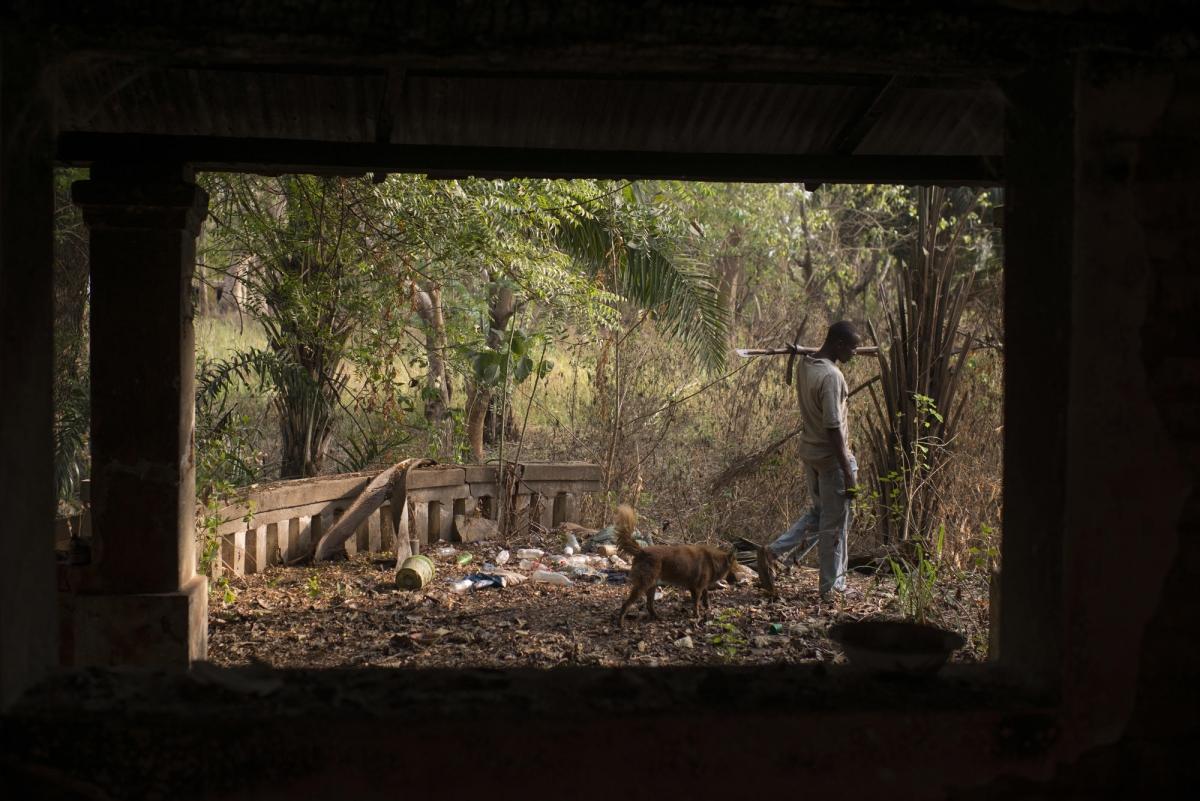 Un homme marche près d'une villa abandonnée.
 © Colin Delfosse/Ouf of Focus