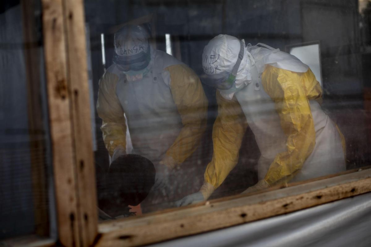 Centre de transit Ebola de Bunia, province d'Ituri, République démocratique du Congo. Le personnel médical, vêtu de combinaisons protectrices intégrales, vérifie l'état des cas suspectés d'avoir contracté le virus Ebola.
 © Pablo Garrigos/MSF