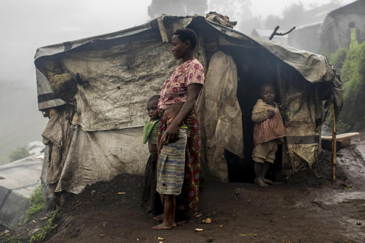Camp de déplacés de Katale, territoire de Masisi, province du Nord-Kivu, République démocratique du Congo. Portrait d'Espérance Zawadi avec ses enfants. Elle est arrivée dans le camp il y a 2 ans et essaie de trouver de l'argent en travaillant dans les champs ou en transportant des marchandises pour 1&nbsp;000 francs congolais par jour (environ 50 centimes d'euros). Elle n'a reçu aucune aide au cours des 6 derniers mois et ses enfants souffrent de malnutrition : «&nbsp;Notre communauté a besoin de nourriture car nous n'avons plus accès à nos champs, nous avons faim&nbsp;», confie-t-elle. En 2019, les équipes MSF à Masisi ont constaté une augmentation importante du nombre d'enfants traités pour malnutrition.
 © Pablo Garrigos/MSF