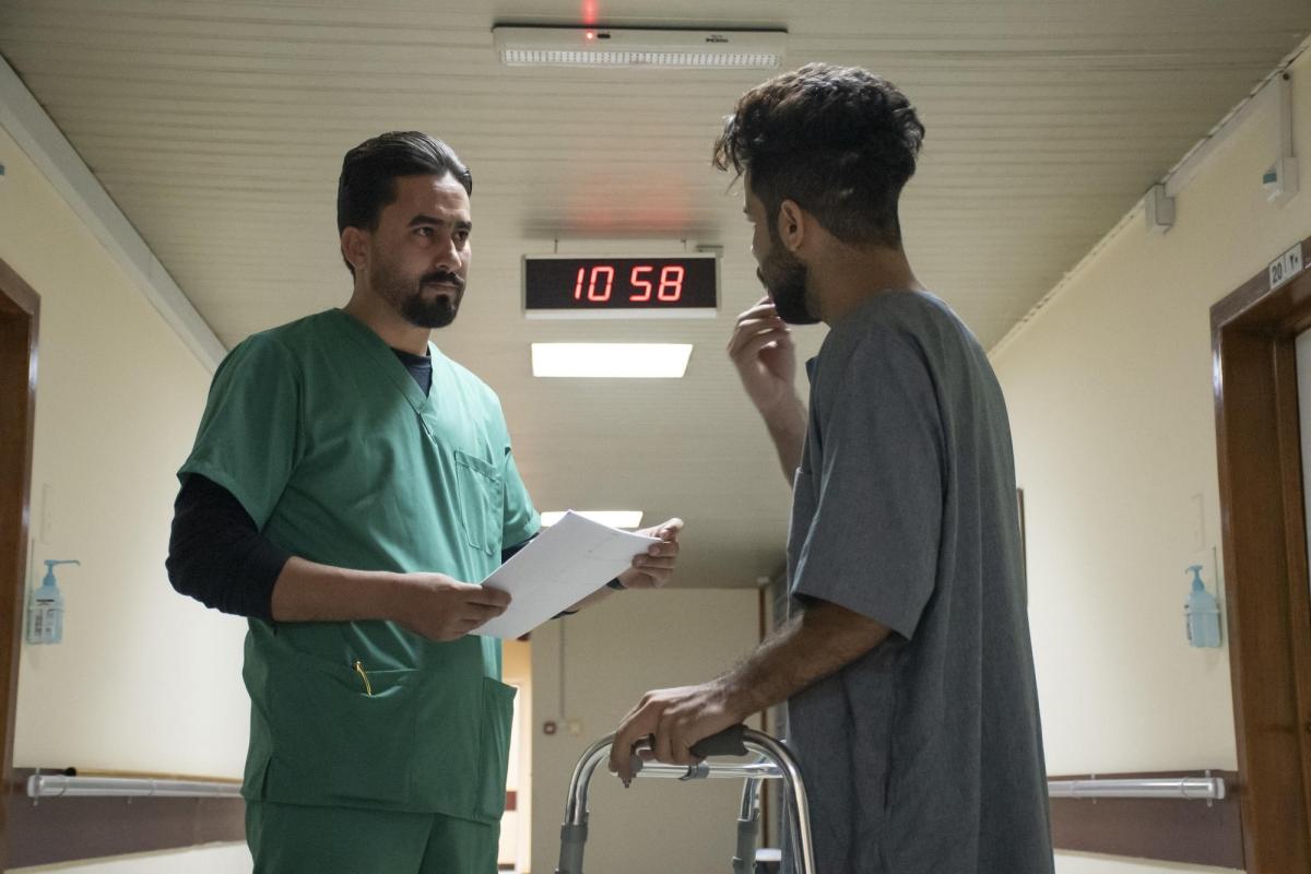 Saif parle à un membre du personnel MSF du centre de réhabilitation médicale de Bagdad. Il a été blessé lorsqu'il a été touché par une cartouche de gaz lacrymogène lors d'une manifestation à Bagdad. Ses blessures étaient si graves que sa jambe a été amputée.
 © Nabil Salih/MSF
