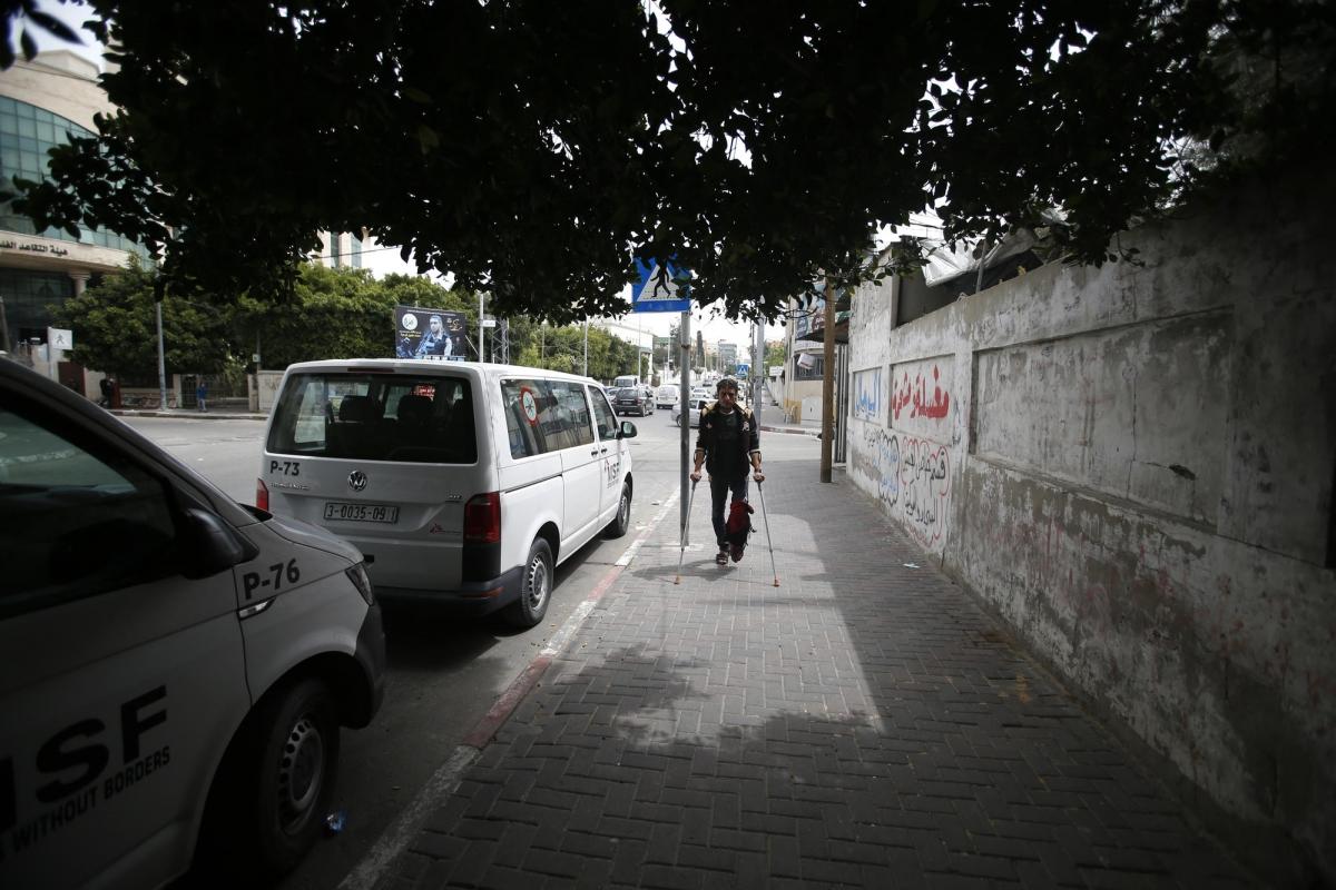 Murad, 26 ans, blessé par l'armée israélienne lors de la grande marche du retour en mai 2018, marche vers la clinique MSF de Gaza city.
 © Mohammed Abed