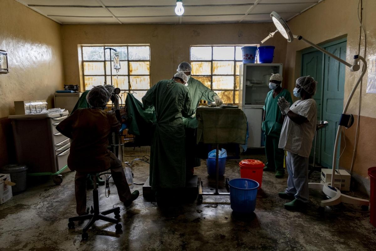 Le docteur Pacifique, directeur de l'hôpital général de Kigulube, et son équipe effectuen une césarienne, dans la pénombre.
 © Pablo Garrigos/MSF