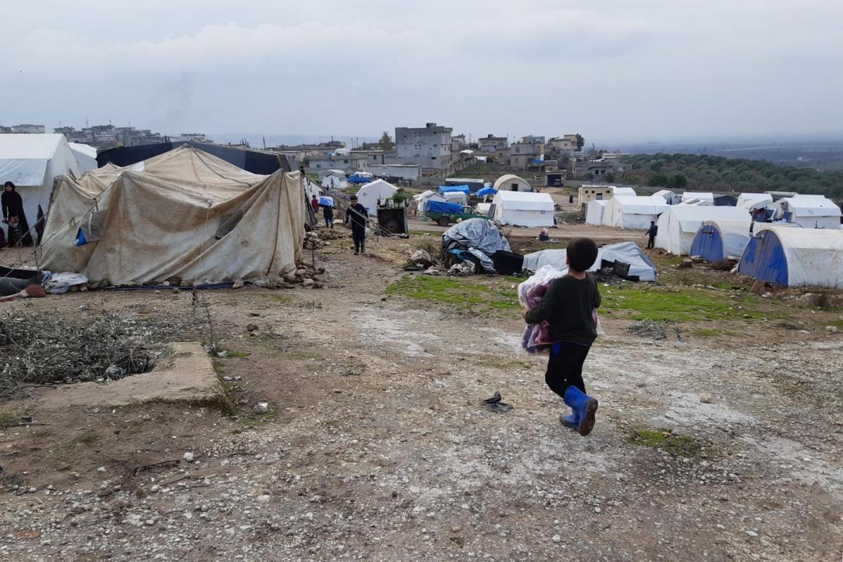 Un enfant retourne dans sa tente, portant des couvertures qu'il a reçues lors d'une distribution MSF. Le camp où lui et sa famille se sont installés, dans la région de Jebel Harem, accueille environ 120 familles.&nbsp;
 © MSF